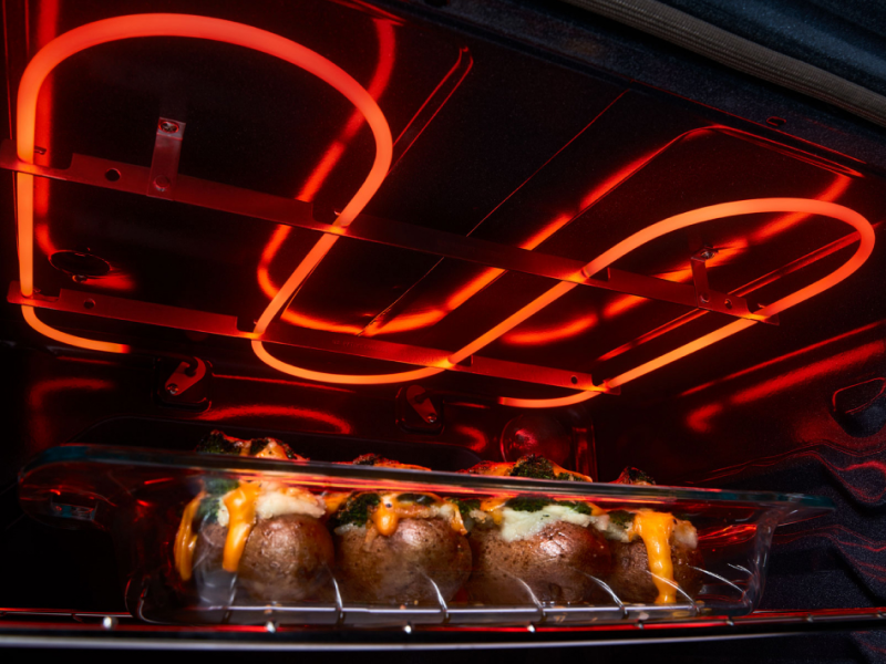 A broiler element broiling baked potatoes in an oven